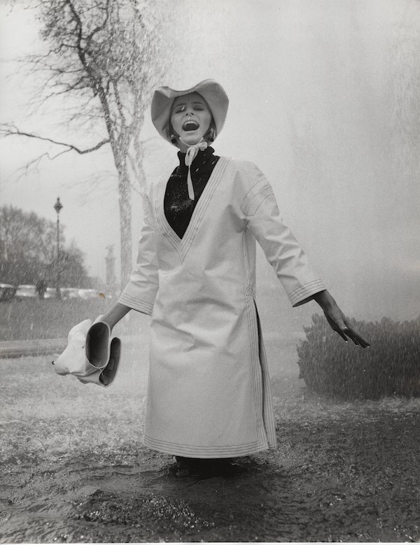 Jill Kennington wearing white PVC rain tunic and hat. Photograph by John Cowan 1963