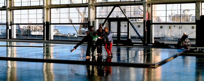 'Against the light, the dancers appear like marionettes framed within grids of glass and steel'